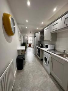 a kitchen with a sink and a clock on the wall at Boutique Style Apartment Belfast in Belfast