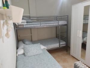 ロス・アルカサレスにあるCASA GORRIÓNの鏡付きの二段ベッド3台が備わる客室です。