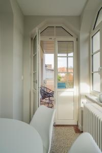 1 dormitorio con una puerta que da a un balcón en Le cocon d'Emma, terrasse, jardin et élégance dans maison de Maître, en Estrasburgo
