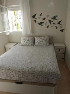 ロス・アルカサレスにあるCASA GORRIÓNのベッドルーム1室(壁に鳥が描かれたベッド1台付)