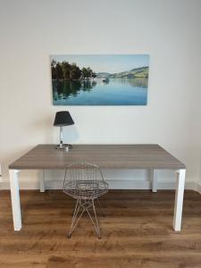 Seengen的住宿－Grosse Einzimmerwohnung/Büro/Showroom，一张木桌、椅子和墙上的绘画