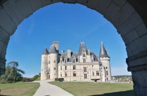 un castello visto attraverso un arco di ponte di Gîte Le P'tit Chez Nous a La Rochefoucauld