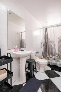 a white bathroom with a sink and a toilet at Habitaciones Valparaiso in Valparaíso