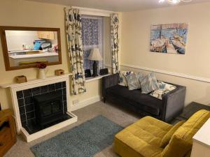a living room with a couch and a fireplace at Cosy 2 Bedroom Apartment near Seafront in Penzance