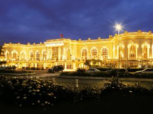 a large building lit up at night with at L'amour à la plage in Deauville