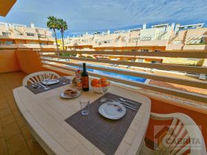 Conceição的住宿－Royal Sunrise T2 by YHA，阳台上的餐桌上摆放着食物和葡萄酒