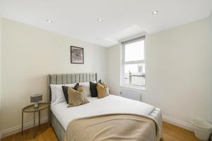 倫敦的住宿－LiveStay - Modern Apartments on Acton Lane，卧室配有一张大白色床和窗户