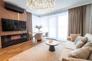 a living room with a couch and a tv and a table at Lake Rental Pratum in Mikołajki