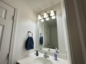 a bathroom with a sink and a large mirror at Great Value! Close to Proctors, Gorgeous Townhouse in Schenectady