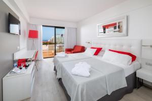 a hotel room with two beds and a television at Alexandre Hotel Gala in Playa de las Americas