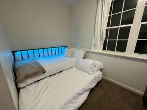 a small bed in a room with a window at Great Value! Close to Proctors, Gorgeous Townhouse in Schenectady