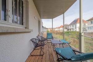 una fila de sillas en un porche con balcón en Le cocon d'Emma, terrasse, jardin et élégance dans maison de Maître, en Estrasburgo