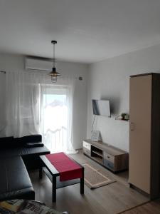 a living room with a couch and a tv at Ellena Sunshine in Opatija