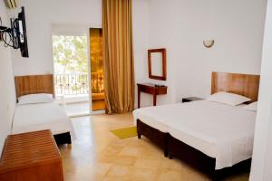 1 dormitorio con 2 camas y balcón en LE GRAND HOTEL en Houmt El Souk