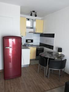 a kitchen with a red refrigerator and a table at Ellena Sunshine in Opatija
