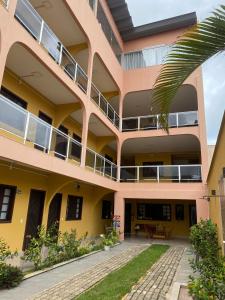 an apartment building with a balcony and a patio at Pousada Martins in São Mateus