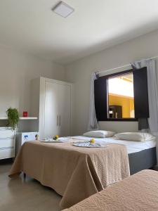 a bedroom with two beds and a window at Pousada Martins in São Mateus