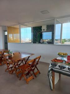 a dining room with tables and chairs and windows at Pousada Martins in São Mateus