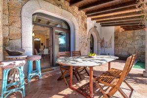 アルゲーロにあるRELAIS APARTMENTS - Villa Deseoのテーブルと椅子のある屋外パティオ