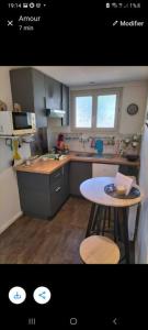 uma pequena cozinha com uma mesa e um lavatório em Studio Marie em Belbeuf