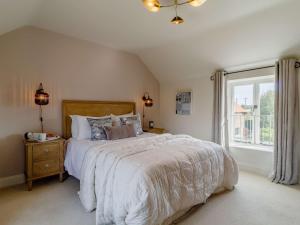 ein Schlafzimmer mit einem großen Bett und einem Fenster in der Unterkunft 3 Bed in Saxmudham 89691 in Aldringham