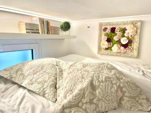 1 dormitorio con 1 cama y una pintura de flores en Yourbanflat Torre Degli Anziani en Padua