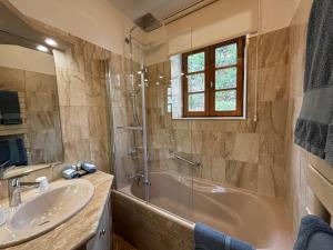 ein Bad mit einer Badewanne, einem Waschbecken und einer Dusche in der Unterkunft Hotel Le Manasses in Curtil-Vergy