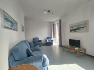 a living room with a blue couch and a tv at MISTRAL House in Levanto