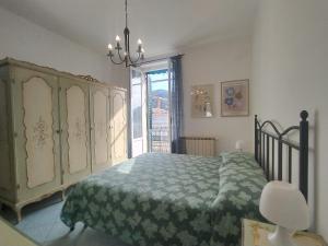 a bedroom with a green bed and a window at MISTRAL House in Levanto