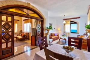 uma sala de estar com uma mesa de jantar e uma sala de estar em Cretan Castle Villas em Chania Town