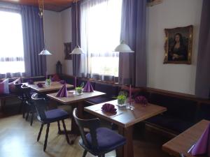 una sala da pranzo con tavoli e sedie con tovaglioli viola di Hotel-Restaurant Zum Goldenen Hahnen a Markgröningen