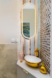a bathroom with a yellow sink and a mirror at Jacuzzi Berka Apartamenty in Krakow