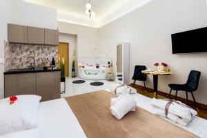 a bedroom with a bed and a kitchen with a bathtub at Jacuzzi Berka Apartamenty in Krakow