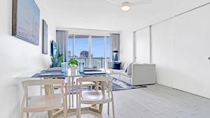 a dining room with a table and chairs and a couch at Luxury High Floor Corner 1BR Unit at W Resort Fort Lauderdale-Well stocked in Fort Lauderdale