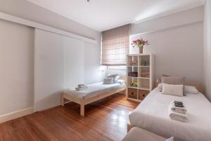 a bedroom with a bed and a bench in it at Arkotxa apartment by People Rentals in Getxo