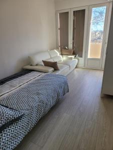 een woonkamer met een bed en een bank bij Elégant apparemment 60m2 climatisé in Avignon