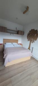 um quarto com uma cama com uma árvore na parede em Triventi z widokiem na Śnieżkę em Karpacz