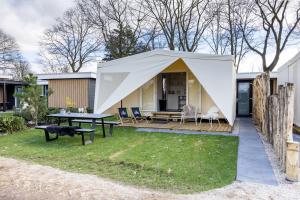 Familiepark TOP Vredeoord في فورتهاوزن: خيمة في الفناء الخلفي لبيت