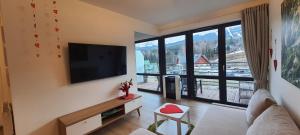uma sala de estar com uma televisão de ecrã plano na parede em Triventi z widokiem na Śnieżkę em Karpacz