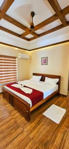 a bedroom with a large bed in a room with wooden floors at ATHIRAPPILY SREENILAYAM HERITAGE RESORt in Athirappilly