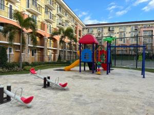 a playground in front of a apartment building with at Thea's Place Arezzo Place in Davao City