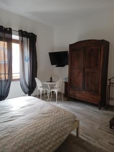 um quarto com uma cama, uma mesa e cadeiras em La Barabbata em Marta