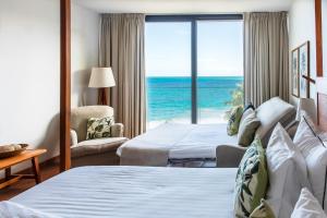een hotelkamer met 2 bedden en uitzicht op de oceaan bij Langley Resort Fort Royal in Deshaies