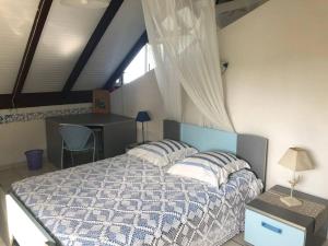 1 dormitorio con cama, escritorio y ventana en Havre entre Mer et Montagne - Le rêve, en Saint-Claude