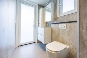 a bathroom with a white toilet and windows at Familiepark TOP Vredeoord in Voorthuizen