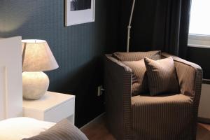 a bedroom with a chair and a lamp on a night stand at Hotell Miskarp in Mjölby