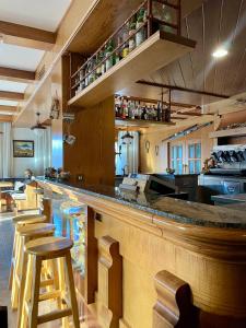 a bar in a restaurant with stools at a counter at Hotel Oasi in San Vito di Cadore