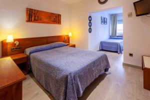 a hotel room with two beds and a television at Hotel Checkin Travé in Figueres