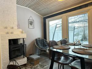 comedor con mesa y chimenea en Cozy cottage in historic surroundings in Langhem, en Länghem