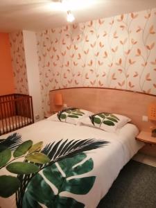 a bedroom with a bed with a leafy wallpaper at gîte vacances in Moncontour